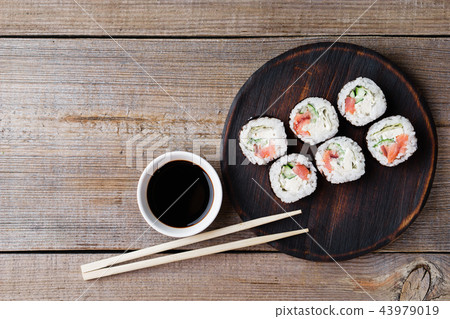 Japanese sushi rolls on wooden plate, flat lay Japanese sushi rolls on wooden plate, flat lay 43979019