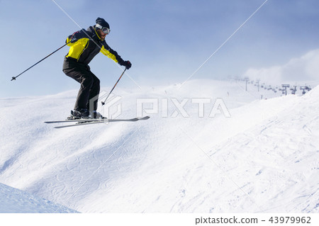 Jumping skier at mountains 43979962