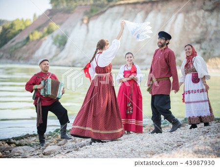 Young people in Russian national costumes pose for the camera on the background of an amazing 43987930
