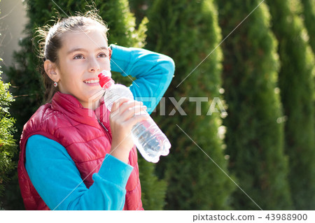 Beautiful girl drinking water after jogging in outdoor 43988900