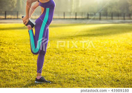 Woman athlete at the morning warm-up at the stadium. Woman athlete at the morning warm-up at the stadium. 43989180