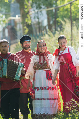 Group of men and women in russian folk costumes in nature. Celebration. Village 43993091