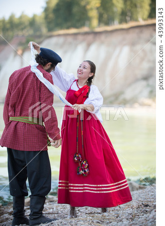 A couple dancing folk dances in Russian national costumes 43993143