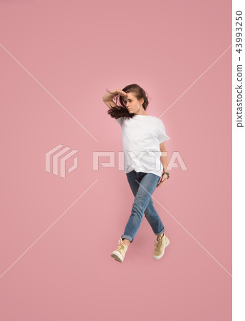 Freedom in moving. Pretty young woman jumping against pink background 43993250