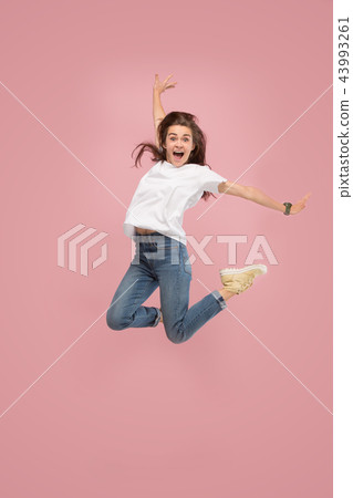 Freedom in moving. Pretty young woman jumping against pink background Freedom in moving. Pretty young woman jumping against pink background 43993261