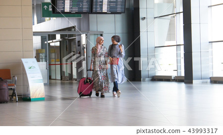 Two muslim girls walk around the airport 43993317