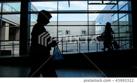 Two womens silhouette walking by the panoramic window background 43993322