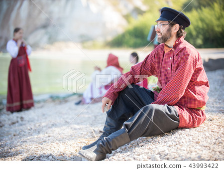 Bearded man in Russian national costume sits on the background of an amazing landscape Bearded man in Russian national costume sits on the background of an amazing landscape 43993422