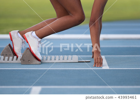 Woman in a starting block on an athletic field 43993461