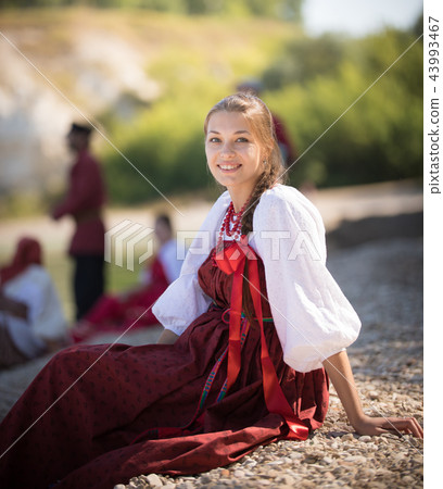 A beautiful girl in Russian national costume pose for the camera on the background of an amazing 43993467
