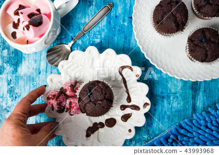 Chocolate muffin and marshmallow on a plate 43993968