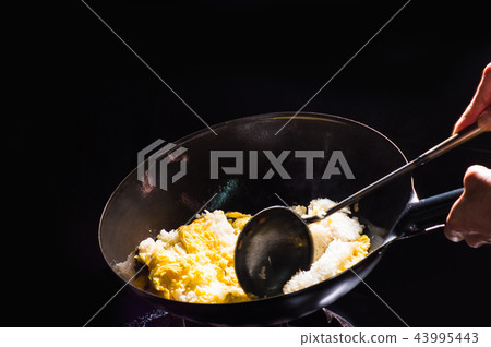 Cooking fried rice in a wok 43995443