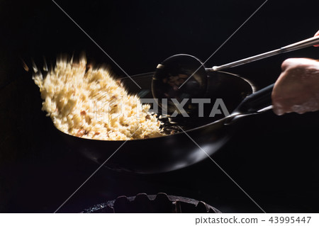 Cooking fried rice in a wok 43995447