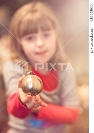 Cute girl holding Christmas decoration 43995960