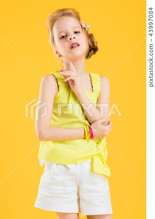 Girl posing on yellow background. 43997084