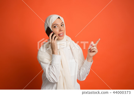 Happy arab woman in hijab. Portrait of smiling girl, posing at studio background 44000373