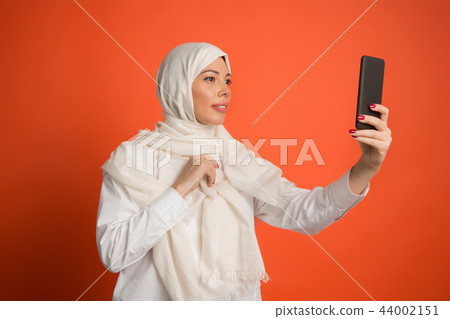 Happy arab woman in hijab. Portrait of smiling girl, posing at studio background 44002151