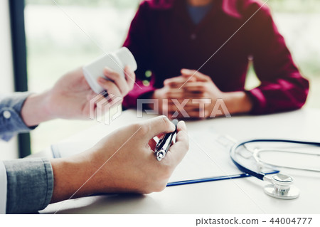Confident doctor man holding a pill bottle Confident doctor man holding a pill bottle 44004777