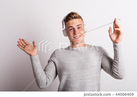 Portrait of a happy young man with headphones in a studio. 44006409