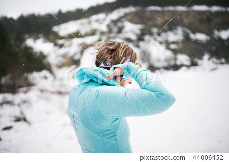 Senior woman runner standing in winter nature, resting. Senior woman runner standing in winter nature, resting. 44006452