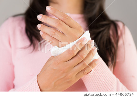 Woman cleaning her hands with a tissue Woman cleaning her hands with a tissue 44006754