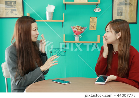 Two OL colleagues to smartphone in a coffee shop Two OL colleagues to smartphone in a coffee shop 44007775