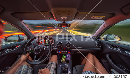 Driver's hands on a steering wheel of a car 44008167