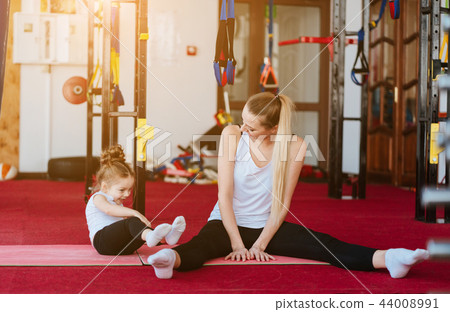 Mom and daughter together perform different exercises 44008991