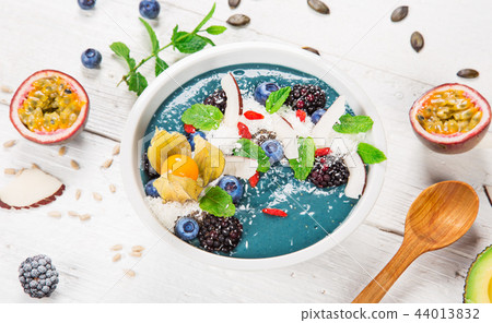 Smoothie bowl with fresh berries, nuts, seeds, fruit and vegetables. Smoothie bowl with fresh berries, nuts, seeds, fruit and vegetables. 44013832