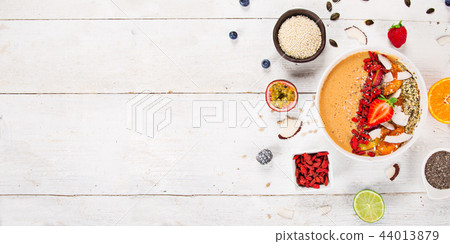 Smoothie bowl with fresh berries, nuts, seeds, fruit and vegetables. Smoothie bowl with fresh berries, nuts, seeds, fruit and vegetables. 44013879
