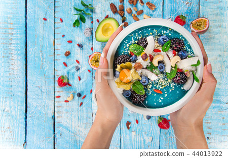 Smoothie bowl with fresh berries, nuts, seeds, fruit and vegetables. Smoothie bowl with fresh berries, nuts, seeds, fruit and vegetables. 44013922