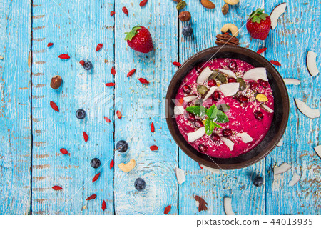 Smoothie bowl with fresh berries, nuts, seeds, fruit and vegetables. Smoothie bowl with fresh berries, nuts, seeds, fruit and vegetables. 44013935