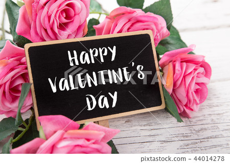 Small chalkboard for Valentine's day. Background with pink roses. 44014278