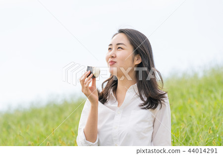 A woman who eats a rice ball 44014291