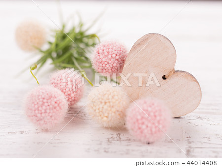 Flowers composition for Valentine's, Mother's or Women's Day. Pink flowers with wooden hearth on old white wooden background. 44014408