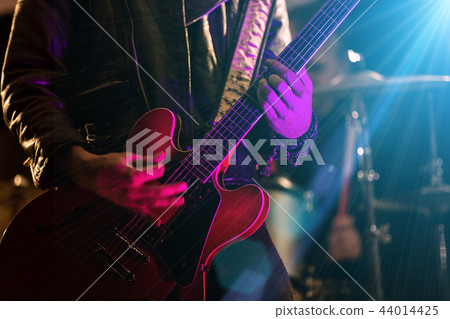 A rocker is playing guitar on stage. A rocker is playing guitar on stage. 44014425