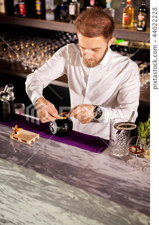 Barman adding cocktail ingredients 44022228