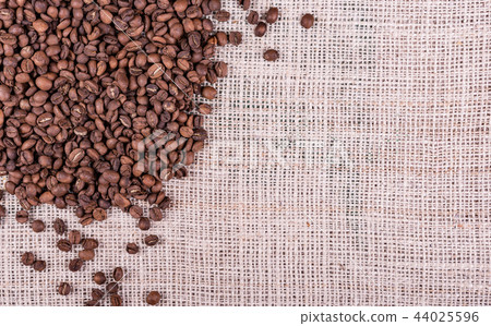 Roasted coffee beans on sack fabric background Roasted coffee beans on sack fabric background 44025596