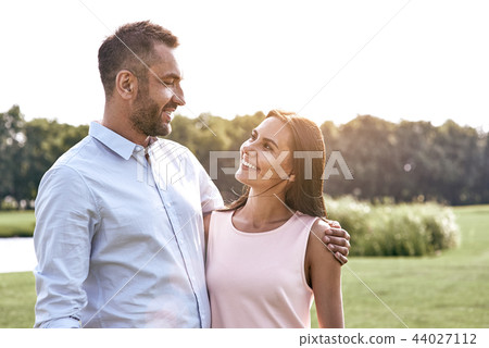 Romantic time. Young couple standing in the park hugging looking 44027112