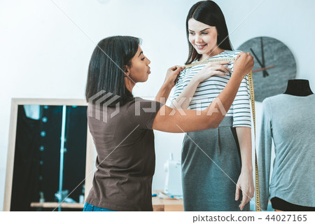 Pleased female person communicating with tailor 44027165