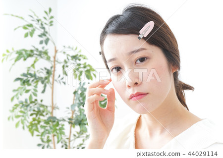 一名年輕女子正在做皮膚護理 一名年輕女子正在做皮膚護理 44029114