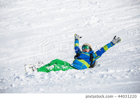 Photo of sports man with snowboard lying on snowy slope 44031220