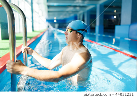 Image on side of young swimmer coming out of indoor pool 44031231
