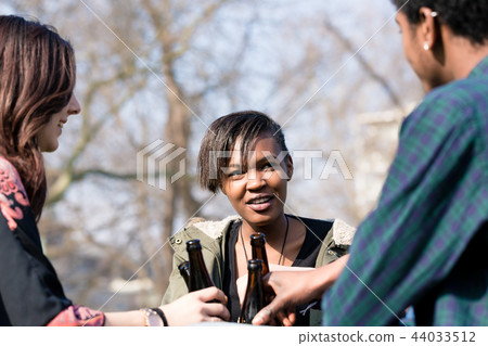 Diverse friends enjoying the drinks in park 44033512