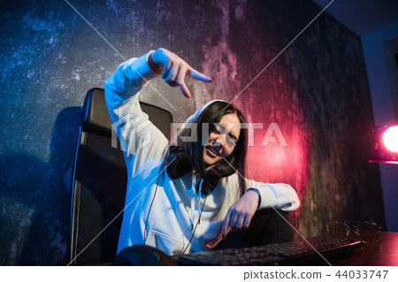 Excited female gamer girl woman pressing a button on a keyboard running a game or sending a message Excited female gamer girl woman pressing a button on a keyboard running a game or sending a message 44033747