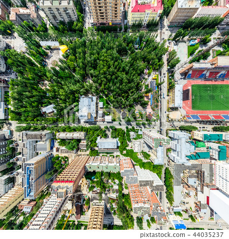 Aerial city view with crossroads and roads, houses, buildings, parks and parking lots. Sunny summer Aerial city view with crossroads and roads, houses, buildings, parks and parking lots. Sunny summer 44035237