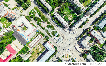Aerial city view with crossroads and roads, houses, buildings, parks and parking lots. Sunny summer Aerial city view with crossroads and roads, houses, buildings, parks and parking lots. Sunny summer 44035278