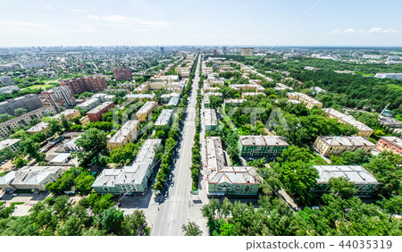 Aerial city view with crossroads and roads, houses, buildings, parks and parking lots. Sunny summer Aerial city view with crossroads and roads, houses, buildings, parks and parking lots. Sunny summer 44035319