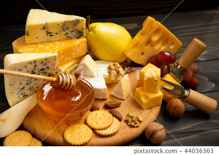 Various types of cheese on a rustic wooden table 44036363