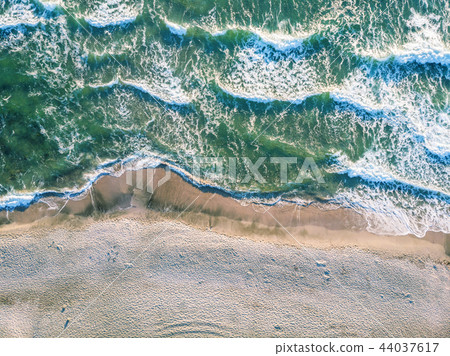 Aerial view of ocean waves crashing on beach. Aerial view of ocean waves crashing on beach. 44037617